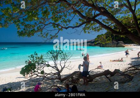 Thailand: Besucher auf Ko Miang (Insel 4), Similan-Inseln. Die Similan-Inseln liegen etwa 100 km nordwestlich von Phuket in der Andamanensee. Im Jahr 1982 wurde diese 128 Quadratkilometer große Fläche zum Meeres-Nationalpark erklärt, und in den letzten Jahren hat sich die Gruppe der neun kleinen Inseln (Similan stammt aus dem malaiischen sembilan und bedeutet neun) zu einer der führenden Attraktionen für Besucher des südlichen Thailands entwickelt. Die Inseln sind bei Tauchern für ihre reichen Korallenriffe, das klare Wasser und die unberührten Strände bekannt. Die besten Tauchmonate sind zwischen Dezember und Mai, wenn das Wetter gut ist. Stockfoto