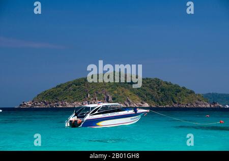 Thailand, Similan-Inseln, Ko Miang (Insel 4), Schnellboot. Die Similan-Inseln liegen etwa 100 km nordwestlich von Phuket in der Andamanensee. Im Jahr 1982 wurde diese 128 Quadratkilometer große Fläche zum Meeres-Nationalpark erklärt, und in den letzten Jahren hat sich die Gruppe der neun kleinen Inseln (Similan stammt aus dem malaiischen sembilan und bedeutet neun) zu einer der führenden Attraktionen für Besucher des südlichen Thailands entwickelt. Die Inseln sind bei Tauchern für ihre reichen Korallenriffe, das klare Wasser und die unberührten Strände bekannt. Die besten Tauchmonate sind zwischen Dezember und Mai. Stockfoto