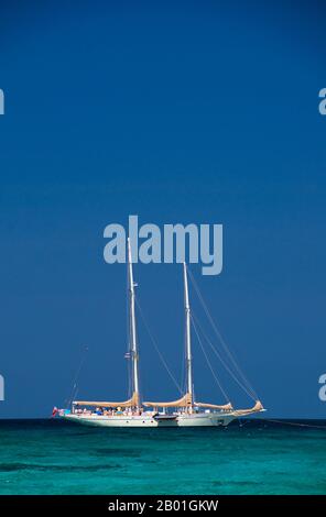 Thailand: Yacht in der Nähe von Ko Miang (Insel 4), Similan-Inseln. Die Similan-Inseln liegen etwa 100 km nordwestlich von Phuket in der Andamanensee. Im Jahr 1982 wurde diese 128 Quadratkilometer große Fläche zum Meeres-Nationalpark erklärt, und in den letzten Jahren hat sich die Gruppe der neun kleinen Inseln (Similan stammt aus dem malaiischen sembilan und bedeutet neun) zu einer der führenden Attraktionen für Besucher des südlichen Thailands entwickelt. Die Inseln sind bei Tauchern für ihre reichen Korallenriffe, das klare Wasser und die unberührten Strände bekannt. Die besten Tauchmonate sind zwischen Dezember und Mai. Stockfoto