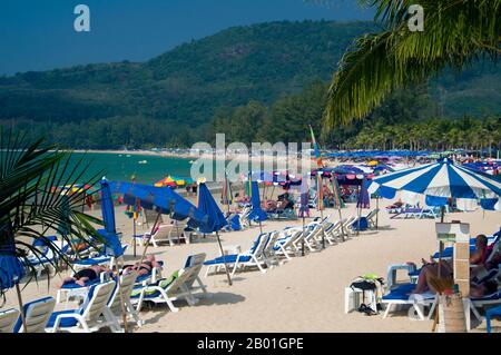 Thailand: Bunte Sonnenschirme, hat Kamala (Kamala Beach), Phuket. Phuket, Thailands größte Insel, liegt in der Andamanensee vor der Küste der Provinz Phang-nga. Die Insel ist 810sq km entfernt. Es ist durch einen weiten Damm mit dem Festland verbunden und hat sich zum luxuriösesten und exquisitesten Strandresort in Thailand entwickelt. Phuket war in den vergangenen Jahrhunderten ein wichtiger Handelsposten am östlichen Ufer der Bucht von Bengal, der Seemänner aus der arabischen und malaiischen Welt, Indien, Birma (Myanmar), China und natürlich Siam. Im 16. Jahrhundert war die Insel auch den Europäern bekannt. Stockfoto