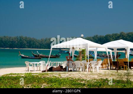 Thailand: Strandrestaurant, hat Nai Yang (Nai Yang Beach), Phuket. Phuket, Thailands größte Insel mit einer Fläche von 810 Quadratkilometern, liegt in der Andamanensee vor der Küste der Provinz Phang-nga. Es ist durch einen weiten Damm mit dem Festland verbunden und hat sich zum luxuriösesten und exquisitesten Strandresort in Thailand entwickelt. Phuket war in den vergangenen Jahrhunderten ein wichtiger Handelsposten am östlichen Ufer der Bucht von Bengal, der Seemänner aus der arabischen und malaiischen Welt, Indien, Birma (Myanmar), China und natürlich Siam. Im 16. Jahrhundert war die Insel auch den Europäern bekannt. Stockfoto