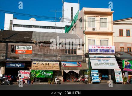 Thailand: Reisebüros und Restaurants in den alten Holzgeschäften in der Nähe des Bahnhofs, Trang, Provinz Trang. Trang ist seit mindestens dem 1. Jahrhundert CE ein Handelszentrum. Sie wuchs zwischen dem 7. Und 13. Jahrhundert während der Srivijaya-Zeit zu Macht und Wohlstand und ist heute noch eine wichtige Handelsstadt. Kautschuk, Palmöl und Fischerei sind die Stützen der Wirtschaft der Provinz. Der Tourismus gewinnt zunehmend an Bedeutung, da die Anadamanküste und die Inseln von Trang zunehmend entwickelt und populär werden. Die Stadt hat einen starken chinesischen Charakter. Stockfoto