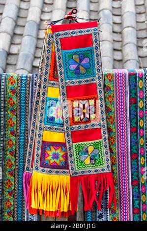 China: Naxi-Kunsthandwerk zum Verkauf in der Altstadt von Lijiang, Provinz Yunnan. Die Naxi oder Nakhi sind eine ethnische Gruppe, die in den Ausläufern des Himalaya im Nordwesten der Provinz Yunnan und im Südwesten der Provinz Sichuan in China lebt. Man geht davon aus, dass die Naxi ursprünglich aus Tibet stammen und bis vor kurzem die Landhandelsverbindungen mit Lhasa und Indien aufrechterhalten haben. Die Naxi sind eine der 56 ethnischen Gruppen, die offiziell von der Volksrepublik China anerkannt werden. Die Naxi sind traditionell Anhänger der Dongba-Religion. Sowohl durch Han-Chinesen als auch durch tibetische Kultur Stockfoto