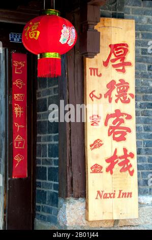 China: Hotelschild mit Naxi (Dongba) und chinesischem Schriftzug, Altstadt von Lijiang, Provinz Yunnan. Die Naxi oder Nakhi sind eine ethnische Gruppe, die in den Ausläufern des Himalaya im Nordwesten der Provinz Yunnan und im Südwesten der Provinz Sichuan in China lebt. Man geht davon aus, dass die Naxi ursprünglich aus Tibet stammen und bis vor kurzem die Landhandelsverbindungen mit Lhasa und Indien aufrechterhalten haben. Die Naxi gehören zu den 56 ethnischen Gruppen, die von der Volksrepublik China offiziell anerkannt wurden. Die Naxi sind traditionell Anhänger der Dongba-Religion. Stockfoto