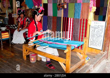 China: Mosuo Weben in der Altstadt von Lijiang, Provinz Yunnan. Die Mosuo (auch Moso oder Musuo), die sich selbst oft als Na bezeichnet, sind eine kleine ethnische Gruppe, die in den Provinzen Yunnan und Sichuan in der Nähe der Grenze zu Tibet lebt. Mit einer Bevölkerung von etwa 40.000 leben die meisten von ihnen in der Region Yongning und rund um den Lugu-See, hoch oben im tibetischen Himalaya. Obwohl sich die Mosuo kulturell von den Nakhi unterscheiden, sieht die chinesische Regierung sie als Mitglieder der Nakhi-Minderheit (auch bekannt als Naxi) an. Die Altstadt von Lijiang reicht mehr als 800 Jahre zurück und war einst eine wichtige Stadt. Stockfoto