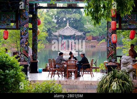 China: Kartenspielen in einem Teehaus im Black Dragon Pool Park, nördlich der Altstadt von Lijiang, Provinz Yunnan. Die Naxi oder Nakhi sind eine ethnische Gruppe, die in den Ausläufern des Himalaya im Nordwesten der Provinz Yunnan und im Südwesten der Provinz Sichuan in China lebt. Man geht davon aus, dass die Naxi ursprünglich aus Tibet stammen und bis vor kurzem die Landhandelsverbindungen mit Lhasa und Indien aufrechterhalten haben. Die Naxi gehören zu den 56 ethnischen Gruppen, die von der Volksrepublik China offiziell anerkannt wurden. Die Naxi sind traditionell Anhänger der Dongba-Religion. Stockfoto