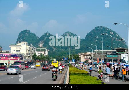 China: Verkehr auf der Befreiungsbrücke mit Sieben-Sterne-Park im Hintergrund, Guilin, Provinz Guangxi. Qixing Gongyuan oder Seven Star Park erhielt seinen Namen durch die Lage der sieben Hügel, die das Muster der Sternbilder des Pflugs (Big Dipper) vermuten lassen. Der Park ist seit mehr als 1.000 Jahren eine Touristenattraktion. Der Name Guilin bedeutet „Cassia Woods“ und ist nach den Osmanthus-(Cassia-)Blüten benannt, die im Herbst blühen. Guilin ist der Schauplatz von Chinas berühmtesten Landschaften und inspiriert Tausende von Gemälden über viele Jahrhunderte. Stockfoto