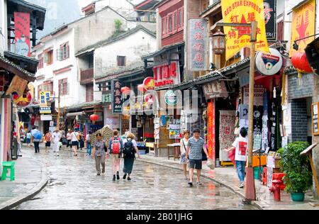 China: Touristen in Xi Jie („Foreigner Street“), Yangshuo, nahe Guilin, Provinz Guangxi. Yangshuo ist zu Recht berühmt für seine dramatische Landschaft. Es liegt am Westufer des Flusses Li (Lijiang) und ist nur 60 Kilometer stromabwärts von Guilin. In den letzten Jahren ist es zu einem beliebten Reiseziel bei Touristen geworden und hat gleichzeitig das Gefühl einer kleinen Flussstadt bewahrt. Guilin ist der Schauplatz von Chinas berühmtesten Landschaften und inspiriert Tausende von Gemälden über viele Jahrhunderte. Sie wurden oft als die „schönsten Berge und Flüsse unter dem Himmel“ bezeichnet. Stockfoto