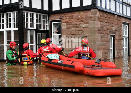 Die Mitglieder des Bergrettungsteams versuchen, einen Mann aus seinem Haus zu retten, der in Monmouth von einem starken Hochwasser umgeben ist, nach dem Sturm Dennis. Stockfoto