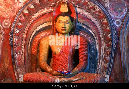 Sri Lanka: Buddha in Asgiriya Vihara (Tempel), Kandy. Asgiriya Vihara, das „Kloster des Pferdebergs“, wurde Anfang des 19. Jahrhunderts von der Familie Pilima Talauve auf einem Grundstück neben dem alten königlichen Feuerbestattung-Gelände erbaut. Der Asgiriya Vihara ist ein eher kleiner, unauffälliger Tempel, aber als einer der Sitze der religiösen Macht Goyigamas von großer Bedeutung. Ab Anfang des 19. Jahrhunderts, während der Esala Perahera, wurde das heilige Zahnrelic für die letzte Nacht des Festivals im Asgiriya Vihara deponiert. Stockfoto