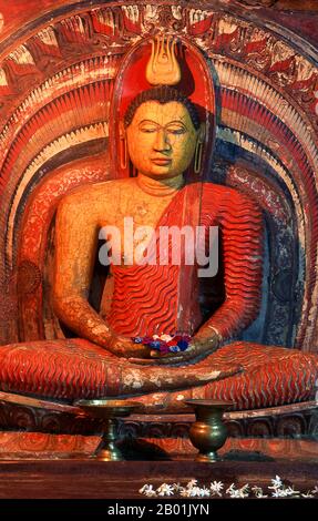 Sri Lanka: Buddha in Asgiriya Vihara (Tempel), Kandy. Asgiriya Vihara, das „Kloster des Pferdebergs“, wurde Anfang des 19. Jahrhunderts von der Familie Pilima Talauve auf einem Grundstück neben dem alten königlichen Feuerbestattung-Gelände erbaut. Der Asgiriya Vihara ist ein eher kleiner, unauffälliger Tempel, aber als einer der Sitze der religiösen Macht Goyigamas von großer Bedeutung. Ab Anfang des 19. Jahrhunderts, während der Esala Perahera, wurde das heilige Zahnrelic für die letzte Nacht des Festivals im Asgiriya Vihara deponiert. Stockfoto