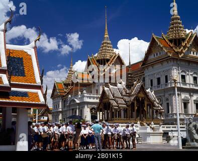 Thailand: Schüler bewundern den Phra Phinang Chakri Maha Prasat, den Großen Palast, Bangkok. Der große Palast diente ab dem 18. Jahrhundert als offizielle Residenz der Könige von Thailand. Der Bau des Palastes begann 1782 während der Regierungszeit von König Rama I., als er die Hauptstadt über den Fluss von Thonburi nach Bangkok verlegte. Stockfoto