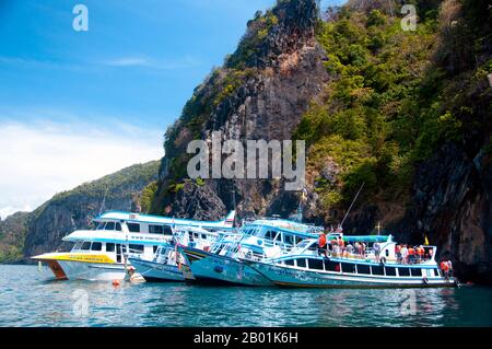 Thailand: Ausflugsboote in Tham Morakot (Smaragdhöhle), Ko Muk, Provinz Trang. Ko Muk oder „Pearl Island“ liegt 13 km südlich von Trang’s Pak Meng Pier. Bis vor kurzem ist Ko Muk ein abgelegenes Reiseziel für Rucksacktouristen mit einer kleinen Einwohnerzahl von Chao Lae „Sea Gypsies“ und entwickelt sich schnell zu einem höherwertigen Reiseziel. Tham Morakot oder „Smaragdhöhle“ ist eine der wichtigsten lokalen Attraktionen. Besucher müssen etwa 75 Meter (240 ft) durch eine wassergefüllte Höhle bei Flut schwimmen, ein Teil des Schwimmens befindet sich in virtueller Dunkelheit, um eine hong oder See-gefüllte Lagune zu erreichen. Stockfoto