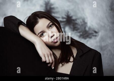 Porträt einer schönen Frau mit langen Haaren auf grauem Hintergrund. Stockfoto