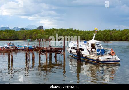 Thailand: Tour mit dem Boot an der Küste von Krabi Town, Provinz Krabi, Südthailand. Einst ein einfacher Fischerhafen, wird Krabi zu einem Öko-Touristenzentrum und zum Haupteinschiffungspunkt für Inseln wie Ko Lanta im Süden, Ko Phi Phi im Südwesten und die Strände um Ao Nang im Westen. Am Ufer der Mündung von Krabi gelegen, soll die Stadt ihren Namen von einem Schwert oder krabi haben, das angeblich in der Nähe entdeckt wurde. Die Umgebung von Krabi zeichnet sich durch hohe Kalksteinfelsen aus, eine Art Phang-Nag-Bucht an Land, die zum Symbol der Provinz Krabi geworden sind. Stockfoto