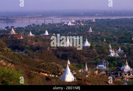 Birma/Myanmar: Ein Meer von Pagoden bei Sagaing, die Ava-Brücke über den Irrawaddy/Ayeyarwady in der Ferne. Sagaing ist die Hauptstadt der Region Sagaing (ehemals Sagaing Division) in Myanmar. Sagaing liegt am Ayeyarwady River, 20 km südwestlich von Mandalay am gegenüberliegenden Ufer des Flusses. Mit vielen buddhistischen Klöstern ist Sagaing ein wichtiges religiöses und klösterliches Zentrum. Die Pagoden und Klöster bevölkern die zahlreichen Hügel entlang des Berges, der parallel zum Fluss verläuft. Die zentrale Pagode, bald U Ponya Shin Pagode, ist durch eine Reihe überdachter Treppen verbunden, die den 240 m hohen Hügel hinaufführen. Stockfoto