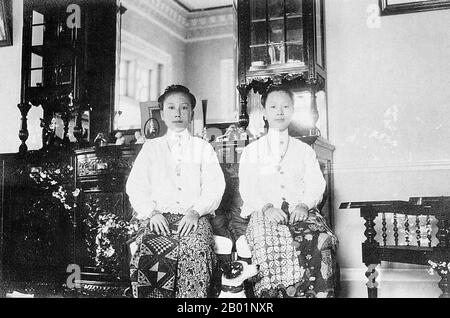 Malaysia/Singapur: Zwei Peranakan-Damen im Nyonya-Stil, ca. 1930er Jahre Peranakan Chinese und Baba-Nyonya sind die Bezeichnungen für die Nachkommen chinesischer Einwanderer aus dem späten 15. Und 16. Jahrhundert, die während der Kolonialzeit in den malaiisch-indonesischen Archipel von Nusantara kamen. Mitglieder dieser Gemeinde in Malaysia bezeichnen sich als „Nyonya-Baba“ oder „Baba-Nyonya“. Nyonya ist der Begriff für die Weibchen und Baba für die Männchen. Sie gilt insbesondere für die ethnischen chinesischen Bevölkerungsgruppen der British Straits Settlements in Malaya und der von den Niederlanden kontrollierten Insel Java und anderen Orten. Stockfoto