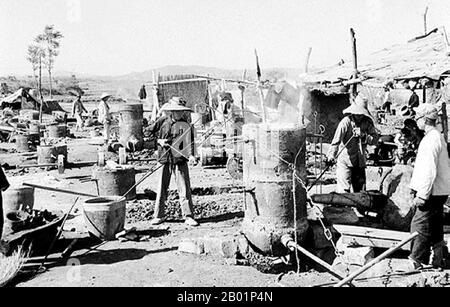 China: Ländliche Industrialisierung durch "Hinterhoföfen"-Arbeiter während des großen Sprünges nach vorne (1958-1961). Der große Sprung nach vorne in der Volksrepublik China (VR China) war eine wirtschaftliche und soziale Kampagne der Kommunistischen Partei Chinas (KPC), die sich in Planungsentscheidungen von 1958 bis 1961 widerspiegelte. die darauf abzielte, Chinas riesige Bevölkerung zu nutzen, um das Land durch den Prozess der raschen Industrialisierung und Kollektivierung rasch von einer Agrarwirtschaft in eine moderne kommunistische Gesellschaft zu verwandeln. Mao Zedong leitete die Kampagne auf der Grundlage der Theorie der produktiven Kräfte. Stockfoto