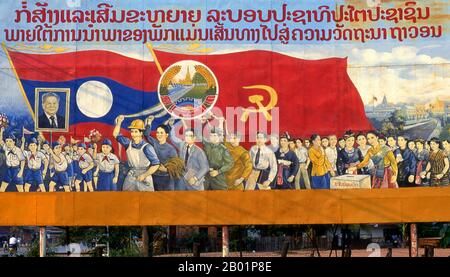 Laos: Die Kinder tragen ein Bild von Kaysone Phomvihane, dem ehemaligen Präsidenten von Laos. Revolutionäres sozialistisches Poster auf den Straßen von Vientiane. Kaysone Phomvihane (* 13. Dezember 1920 bis 21. November 1992) war ab 1955 Führer der laotischen Revolutionären Volkspartei. Er war von 1975 bis 1991 erster Premierminister der Demokratischen Volksrepublik Laos und von 1991 bis zu seinem Tod 1992 Präsident. Der sozialistische Realismus ist ein Stil realistischer Kunst, der in der Sowjetunion entwickelt wurde und in anderen kommunistischen Ländern zu einem dominierenden Stil wurde. Stockfoto