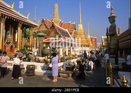 Thailand: Menschen zünden Weihrauch am Chao Mae Guan im (Guanyin) Schrein vor dem Ubosot, Wat Phra Kaew, Bangkok. Wat Phra Kaew (Tempel des Smaragdbuddhas), offizieller Name Wat Phra Si Rattana Satsadaram, gilt als der heiligste buddhistische Tempel Thailands. Es befindet sich innerhalb des Viertels des Großen Palastes. Der Grand Palace diente ab dem 18. Jahrhundert als offizielle Residenz der Könige von Thailand. Der Bau des Palastes begann 1782, während der Regierungszeit von König Rama I., als er die Hauptstadt über den Fluss verlegte. Stockfoto