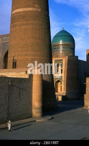 Usbekistan: Das Minarett von Kalyan oder Kalon mit der Kuppel der mir-i-arabischen Madrasah im Hintergrund, Teil des Po-i-Kalyan-Komplexes, Buchara. Die Kalyan-Moschee ist Bucharas Gemeindemoschee oder Freitagsmoschee. Sie wurde im 16. Jahrhundert an der Stelle einer älteren Moschee errichtet, die von Dschingis Khan zerstört wurde. Das kalyanische Minarett oder Minâra-i Kalân (pesianisch/tadschikisch für das „große Minarett“) ist Teil des Po-i-Kalyan-Moschee-Komplexes und wurde von Bako entworfen und 1127 vom arachanidischen Herrscher Arslan Khan erbaut. Das Minarett ist in Form eines Rundsäulenturms aus Ziegelstein gefertigt, der sich nach oben verengt. Stockfoto