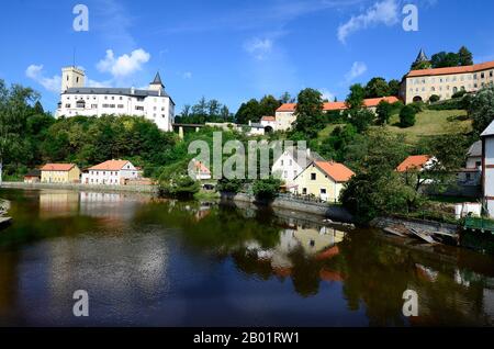 Rozmberk nad Vltavou, Tschechien - 11. August 2013: Schloss und Häuser, die in der Moldau (Moldau-Fluss) in Böhmen reflektiert werden Stockfoto