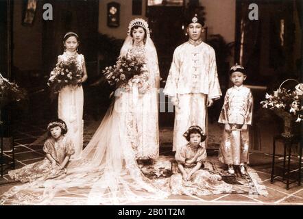 Malaysia/Singapur: Eine Peranakan Braut und Bräutigam posieren für ihr Hochzeitsfoto, Singapur, ca. 1925. Peranakan Chinese und Baba-Nyonya sind die Bezeichnungen für die Nachkommen chinesischer Einwanderer aus dem späten 15. Und 16. Jahrhundert, die während der Kolonialzeit in den malaiisch-indonesischen Archipel von Nusantara kamen. Mitglieder dieser Gemeinde in Malaysia bezeichnen sich als „Nyonya-Baba“ oder „Baba-Nyonya“. Nyonya ist der Begriff für die Weibchen und Baba für die Männchen. Sie gilt insbesondere für die ethnischen chinesischen Bevölkerungsgruppen der British Straits Settlements in Malaya und der von den Niederlanden kontrollierten Insel Java. Stockfoto