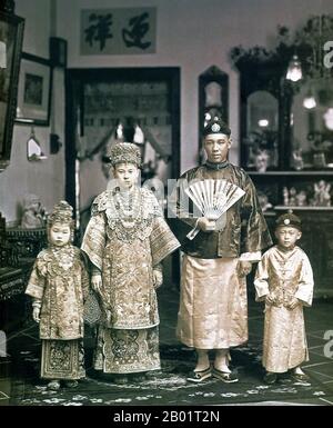 Malaysia/Singapur: Eine Peranakan Braut und Bräutigam posieren für ihr Hochzeitsfoto, Singapur, ca. 1930. Peranakan Chinese und Baba-Nyonya sind die Bezeichnungen für die Nachkommen chinesischer Einwanderer aus dem späten 15. Und 16. Jahrhundert, die während der Kolonialzeit in den malaiisch-indonesischen Archipel von Nusantara kamen. Mitglieder dieser Gemeinde in Malaysia bezeichnen sich als „Nyonya-Baba“ oder „Baba-Nyonya“. Nyonya ist der Begriff für die Weibchen und Baba für die Männchen. Sie gilt insbesondere für die ethnischen chinesischen Bevölkerungsgruppen der British Straits Settlements in Malaya und der von den Niederlanden kontrollierten Insel Java. Stockfoto