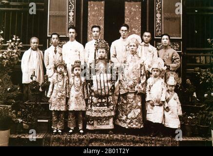 Malaysia/Singapur: Eine Peranakan Braut und Bräutigam posieren für ihr Hochzeitsfoto, Penang, ca. 1920. Peranakan Chinese und Baba-Nyonya sind die Bezeichnungen für die Nachkommen chinesischer Einwanderer aus dem späten 15. Und 16. Jahrhundert, die während der Kolonialzeit in den malaiisch-indonesischen Archipel von Nusantara kamen. Mitglieder dieser Gemeinde in Malaysia bezeichnen sich als „Nyonya-Baba“ oder „Baba-Nyonya“. Nyonya ist der Begriff für die Weibchen und Baba für die Männchen. Sie gilt insbesondere für die ethnischen chinesischen Bevölkerungsgruppen der British Straits Settlements in Malaya und der von den Niederlanden kontrollierten Insel Java. Stockfoto