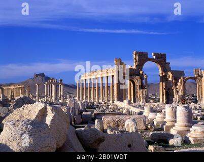 Syrien: Die große Kolonnade und die Burg Qala’at Ibn Maan über den Ruinen von Palmyra. Die arabische Burg Qala’at Ibn Maan (auch bekannt als Fakhr-al-DIN al-Maani), die auf einem Hügel über den Ruinen liegt, wurde ursprünglich von den Mamluken im 13. Jahrhundert erbaut. Palmyra war eine antike Stadt in Syrien. Es war eine wichtige Stadt in Zentralsyrien, in einer Oase 215 km nordöstlich von Damaskus und 180 km südwestlich des Euphrat bei Deir EZ-Zor gelegen. Sie war lange Zeit eine lebenswichtige Karawanenstadt für Reisende, die die syrische Wüste durchquerten, und wurde als Braut der Wüste bekannt. Stockfoto