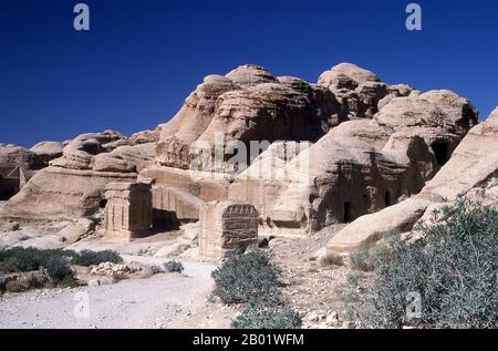 Jordanien: Die Djinn Blöcke (eigentlich Gräber) im Siq (Schacht), Petra. Der Siq oder al-Siq („der Schacht“) ist der Haupteingang zur antiken Stadt Petra im südlichen Jordanien. Die dunkle, schmale Schlucht (an einigen Stellen nicht mehr als 3 Meter breit) windet sich etwa 1,5 km und endet bei Petras aufwändigster Ruine, Al Khazneh (die Schatzkammer). Petra wurde im 4. Jahrhundert v. Chr. von den nabatäischen Arabern als Stadt gegründet und verdankt seine Geburt und seinen Wohlstand der Tatsache, dass es der einzige Ort mit klarem und reichlich Wasser zwischen den Hijaz-Handelszentren Mekka und Medina war. Stockfoto