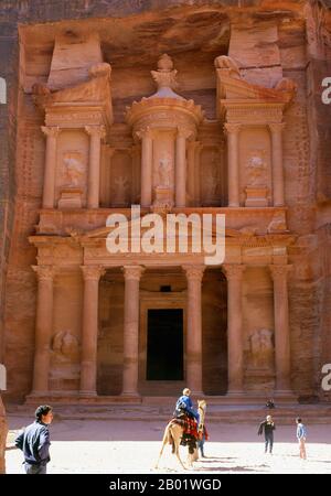 Jordanien: Al Khazneh („Das Finanzministerium“), Petra. Al Khazneh ist eines der raffiniertesten Gebäude in der alten jordanischen Stadt Petra. Wie bei den meisten anderen Gebäuden in dieser antiken Stadt, einschließlich des Klosters (arabisch ad Deir), wurde auch dieses Gebäude aus einer Sandsteinwand gemeißelt. Es hat klassisch griechisch beeinflusste Architektur. Petra wurde im 4. Jahrhundert v. Chr. von den nabatäischen Arabern als Stadt gegründet und verdankt seine Geburt und seinen Wohlstand der Tatsache, dass es der einzige Ort mit klarem und reichlich Wasser zwischen den Hijaz-Handelszentren Mekka und Medina war. Stockfoto