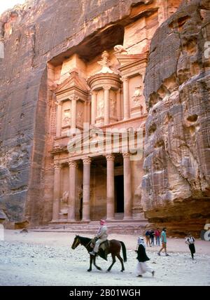 Jordanien: Al Khazneh („Das Finanzministerium“), Petra. Al Khazneh ist eines der raffiniertesten Gebäude in der alten jordanischen Stadt Petra. Wie bei den meisten anderen Gebäuden in dieser antiken Stadt, einschließlich des Klosters (arabisch ad Deir), wurde auch dieses Gebäude aus einer Sandsteinwand gemeißelt. Es hat klassisch griechisch beeinflusste Architektur. Petra wurde im 4. Jahrhundert v. Chr. von den nabatäischen Arabern als Stadt gegründet und verdankt seine Geburt und seinen Wohlstand der Tatsache, dass es der einzige Ort mit klarem und reichlich Wasser zwischen den Hijaz-Handelszentren Mekka und Medina war. Stockfoto