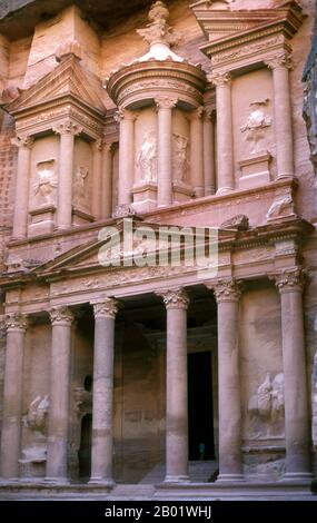 Jordanien: Al Khazneh („Das Finanzministerium“), Petra. Al Khazneh ist eines der raffiniertesten Gebäude in der alten jordanischen Stadt Petra. Wie bei den meisten anderen Gebäuden in dieser antiken Stadt, einschließlich des Klosters (arabisch ad Deir), wurde auch dieses Gebäude aus einer Sandsteinwand gemeißelt. Es hat klassisch griechisch beeinflusste Architektur. Petra wurde im 4. Jahrhundert v. Chr. von den nabatäischen Arabern als Stadt gegründet und verdankt seine Geburt und seinen Wohlstand der Tatsache, dass es der einzige Ort mit klarem und reichlich Wasser zwischen den Hijaz-Handelszentren Mekka und Medina war. Stockfoto