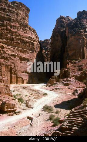 Jordanien: Die Straße der Fassaden aus Sicht des Theaters, Petra. Petra wurde im 4. Jahrhundert v. Chr. von den nabatäischen Arabern als Stadt gegründet und verdankt seine Geburt und seinen Wohlstand der Tatsache, dass es der einzige Ort mit klarem und reichlich Wasser zwischen den Hidschas-Handelszentren Mekka und Medina und Palästina war. Direkt in die nubischen Sandsteinkämme der südjordanischen Wüste gehauen, scheint es wahrscheinlich, dass Petra aufgrund seiner hervorragenden Verteidigungslage und der guten Wasserversorgung seit der paläolithischen Zeit fortwährend besetzt wurde. Stockfoto