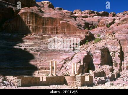 Jordanien: Das Theater im 1. Jahrhundert n. Chr., Petra. Petra wurde im 4. Jahrhundert v. Chr. von den nabatäischen Arabern als Stadt gegründet und verdankt seine Geburt und seinen Wohlstand der Tatsache, dass es der einzige Ort mit klarem und reichlich Wasser zwischen den Hidschas-Handelszentren Mekka und Medina und Palästina war. Direkt in die nubischen Sandsteinkämme der südjordanischen Wüste gehauen, scheint es wahrscheinlich, dass Petra aufgrund seiner hervorragenden Verteidigungslage und der guten Wasserversorgung seit der paläolithischen Zeit fortwährend besetzt wurde. Es wird vermutet, dass es in der Bibel erwähnt wird. Stockfoto