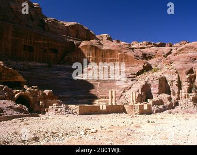 Jordanien: Das Theater im 1. Jahrhundert n. Chr., Petra. Petra wurde im 4. Jahrhundert v. Chr. von den nabatäischen Arabern als Stadt gegründet und verdankt seine Geburt und seinen Wohlstand der Tatsache, dass es der einzige Ort mit klarem und reichlich Wasser zwischen den Hidschas-Handelszentren Mekka und Medina und Palästina war. Direkt in die nubischen Sandsteinkämme der südjordanischen Wüste gehauen, scheint es wahrscheinlich, dass Petra aufgrund seiner hervorragenden Verteidigungslage und der guten Wasserversorgung seit der paläolithischen Zeit fortwährend besetzt wurde. Es wird vermutet, dass es in der Bibel erwähnt wird. Stockfoto