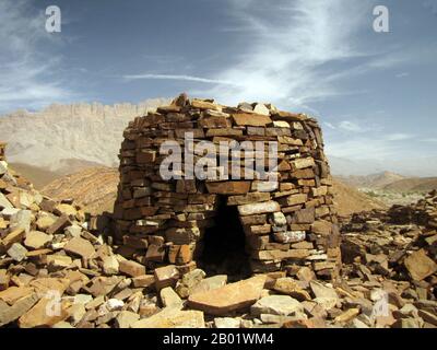 Oman: Altes Steingrab in Al Ayn, nahe bat, ca. 3500-2500 v. Chr. Die frühesten aus Stein gebauten Gräber, die man als „Bienenstock“ bezeichnen kann, befinden sich im Oman, erbaut aus gestapelten flachen Steinen, die in nahe gelegenen geologischen Formationen vorkommen. Sie datieren auf 3500 bis 2500 Jahre v. Chr., in einer Zeit, in der die arabische Halbinsel viel mehr Niederschläge als heute erregte und eine blühende Zivilisation in der heutigen Wüste, westlich des Gebirges am Golf von Oman, unterstützte. Aus diesen „Gräbern“ wurden bisher keine Grabreste gefunden, obwohl es keinen anderen Zweck für ihren Bau gibt. Stockfoto