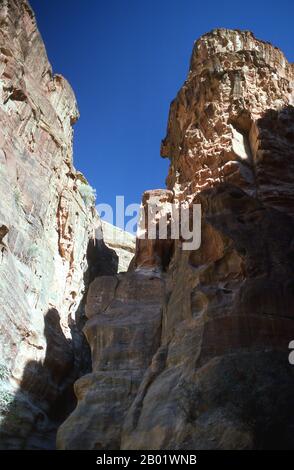 Jordanien: Der Siq (Schacht), der zur antiken Stadt Petra führt. Der Siq oder al-Siq ist der Haupteingang zur antiken Stadt Petra im südlichen Jordanien. Die dunkle, schmale Schlucht (an einigen Stellen nicht mehr als 3 Meter breit) windet sich etwa 1,5 km und endet bei Petras aufwändigster Ruine, Al Khazneh (die Schatzkammer). Petra wurde im 4. Jahrhundert v. Chr. von den nabatäischen Arabern als Stadt gegründet und verdankt seine Geburt und seinen Wohlstand der Tatsache, dass es der einzige Ort mit klarem und reichlich Wasser zwischen den Hidschas-Handelszentren Mekka und Medina und Palästina war. Stockfoto