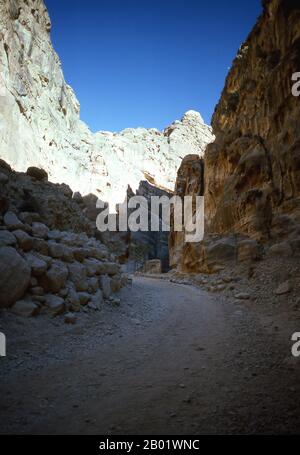 Jordanien: Ein kleines Grab im Siq (Schacht), das zur antiken Stadt Petra führt. Der Siq oder al-Siq ist der Haupteingang zur antiken Stadt Petra im südlichen Jordanien. Die dunkle, schmale Schlucht (an einigen Stellen nicht mehr als 3 Meter breit) windet sich etwa 1,5 km und endet bei Petras aufwändigster Ruine, Al Khazneh (die Schatzkammer). Petra wurde im 4. Jahrhundert v. Chr. von den nabatäischen Arabern als Stadt gegründet und verdankt seine Geburt und seinen Wohlstand der Tatsache, dass es der einzige Ort mit klarem und reichlich Wasser zwischen den Hidschas-Handelszentren Mekka und Medina und Palästina war. Stockfoto