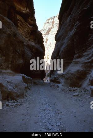 Jordanien: Ein einsamer Reiter im Siq (Schacht), der zur antiken Stadt Petra führt. Der Siq oder al-Siq ist der Haupteingang zur antiken Stadt Petra im südlichen Jordanien. Die dunkle, schmale Schlucht (an einigen Stellen nicht mehr als 3 Meter breit) windet sich etwa 1,5 km und endet bei Petras aufwändigster Ruine, Al Khazneh (die Schatzkammer). Petra wurde im 4. Jahrhundert v. Chr. von den nabatäischen Arabern als Stadt gegründet und verdankt seine Geburt und seinen Wohlstand der Tatsache, dass es der einzige Ort mit klarem und reichlich Wasser zwischen den Hidschas-Handelszentren Mekka und Medina und Palästina war. Stockfoto