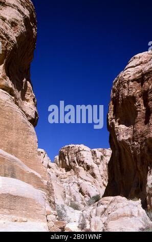 Jordanien: Der Siq (Schacht), der zur antiken Stadt Petra führt. Der Siq oder al-Siq ist der Haupteingang zur antiken Stadt Petra im südlichen Jordanien. Die dunkle, schmale Schlucht (an einigen Stellen nicht mehr als 3 Meter breit) windet sich etwa 1,5 km und endet bei Petras aufwändigster Ruine, Al Khazneh (die Schatzkammer). Petra wurde im 4. Jahrhundert v. Chr. von den nabatäischen Arabern als Stadt gegründet und verdankt seine Geburt und seinen Wohlstand der Tatsache, dass es der einzige Ort mit klarem und reichlich Wasser zwischen den Hidschas-Handelszentren Mekka und Medina und Palästina war. Stockfoto