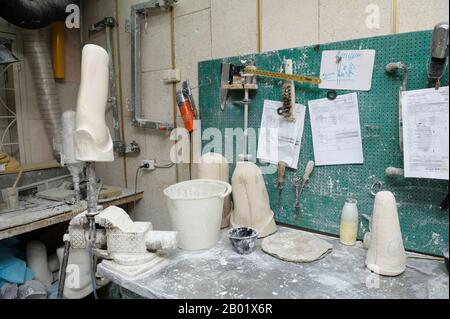 In der Prothesenwerkstatt. Holzrohlinge, Tischhalter, Töpfe und Werkzeuge auf einem Arbeitstisch zur Herstellung künstlicher Gliedmaßen Stockfoto