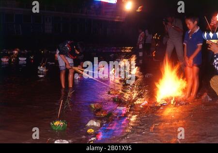 Laos: Fackeln, Krathongs und Feuer erleuchten die Ufer des Mekong-Flusses, Bun Nam Festival, Vientiane. In Laos feiert das awk Phansaa (awk Watsa, Vollmond) Festival das Ende des dreimonatigen Regens. Mönche dürfen die Klöster verlassen, um zu reisen und werden mit Gewändern, Almosenschalen und anderen Voraussetzungen für das entlassene Leben überreicht. Am Vorabend von awk Phansaa bauen viele Menschen kleine Bananenblattboote mit Kerzen, Weihrauch und anderen Opfergaben und treiben sie in Flüssen, ein Brauch, der als Lai Hua Fai bekannt ist, ähnlich wie Loy Krathong in Thailand. Stockfoto