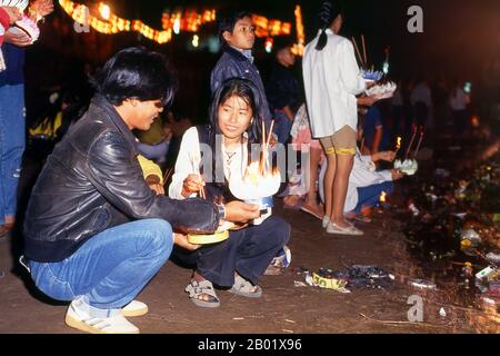 Laos: Junges laotisches Paar, das Krathongs auf dem Mekong-Fluss startet, Bun Nam Festival (Lao Loy Krathong), Vientiane. In Laos feiert das awk Phansaa (awk Watsa, Vollmond) Festival das Ende des dreimonatigen Regens. Mönche dürfen die Klöster verlassen, um zu reisen und werden mit Gewändern, Almosenschalen und anderen Voraussetzungen für das entlassene Leben überreicht. Am Vorabend von awk Phansaa bauen viele Menschen kleine Bananenblattboote mit Kerzen, Weihrauch und anderen Opfergaben und treiben sie in Flüssen, ein Brauch, der als Lai Hua Fai bekannt ist, ähnlich wie Loy Krathong in Thailand. Stockfoto