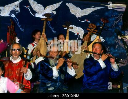 China: Das Naxi (Nakhi) Folk Orchestra, Naxi Orchestra Hall, Lijiang Old Town, Provinz Yunnan. Naxi-Musik ist 500 Jahre alt und hat mit ihrer Mischung aus literarischen Texten, poetischen Themen und Musikstilen aus der Tang-, Song- und Yuan-Dynastie sowie einigen tibetischen Einflüssen einen eigenen Stil und Eigenschaften entwickelt. Es gibt drei Hauptstile: Baisha, Dongjing und Huangjing, alle mit traditionellen chinesischen Instrumenten. Die Naxi oder Nakhi sind eine ethnische Gruppe, die in den Ausläufern des Himalaya im nordwestlichen Teil der Provinz Yunnan lebt. Stockfoto