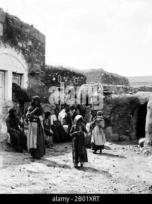 Palästina: Eine palästinensische Bauernfamilie vor ihrem Haus in Kafr Kanna, Galiläa, um 1910. Kafr Kanna ist eine arabische Stadt in der Region Galiläa in Israel, die mit dem Neutestamentsdorf Kana verbunden ist, wo Jesus Wasser in Wein verwandelte. Palästina ist eine Bezeichnung für die geographische Region zwischen dem Mittelmeer und dem Jordanien. Die Region ist auch als das Land Israel, das Heilige Land und die Südlevante bekannt. 1832 wurde Palästina von Mohammed Alis Ägypten erobert, aber 1840 intervenierte Großbritannien und gab die Kontrolle über die Levante an die Osmanen zurück. Stockfoto