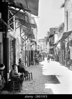 Palästina: Straße der Grabeskirche, Jerusalem, um 1930. Palästina ist ein Name für die geografische Region zwischen dem Mittelmeer und dem Jordan. Die Region ist auch als das Land Israel, das Heilige Land und die Südlevante bekannt. 1832 wurde Palästina von Mohammed Alis Ägypten erobert, aber 1840 intervenierte Großbritannien und gab die Kontrolle über die Levante an die Osmanen zurück, als Gegenleistung für weitere Kapitulationen. Am Ende des 19. Jahrhunderts begann die zionistische Einwanderung und die Wiederbelebung der hebräischen Sprache. Stockfoto