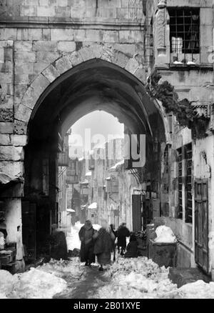 Palästina: Ein Bogengang auf der Via Dolorosa nach starkem Schneefall, Jerusalem, 1921. Palästina ist ein Name für die geografische Region zwischen dem Mittelmeer und dem Jordan. Die Region ist auch als das Land Israel, das Heilige Land und die Südlevante bekannt. 1832 wurde Palästina von Mohammed Alis Ägypten erobert, aber 1840 intervenierte Großbritannien und gab die Kontrolle über die Levante an die Osmanen zurück, als Gegenleistung für weitere Kapitulationen. Am Ende des 19. Jahrhunderts begann die zionistische Einwanderung und die Wiederbelebung der hebräischen Sprache und die Wiederbelebung der hebräischen Sprache. Stockfoto