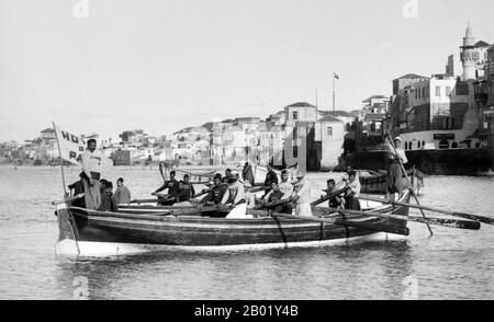 Palästina: Jaffa Boaters, ca. 1910. Palästina ist ein Name für die geografische Region zwischen dem Mittelmeer und dem Jordan. Die Region ist auch als das Land Israel, das Heilige Land und die Südlevante bekannt. 1832 wurde Palästina von Mohammed Alis Ägypten erobert, aber 1840 intervenierte Großbritannien und gab die Kontrolle über die Levante an die Osmanen zurück, als Gegenleistung für weitere Kapitulationen. Am Ende des 19. Jahrhunderts begann die zionistische Einwanderung und die Wiederbelebung der hebräischen Sprache. Stockfoto